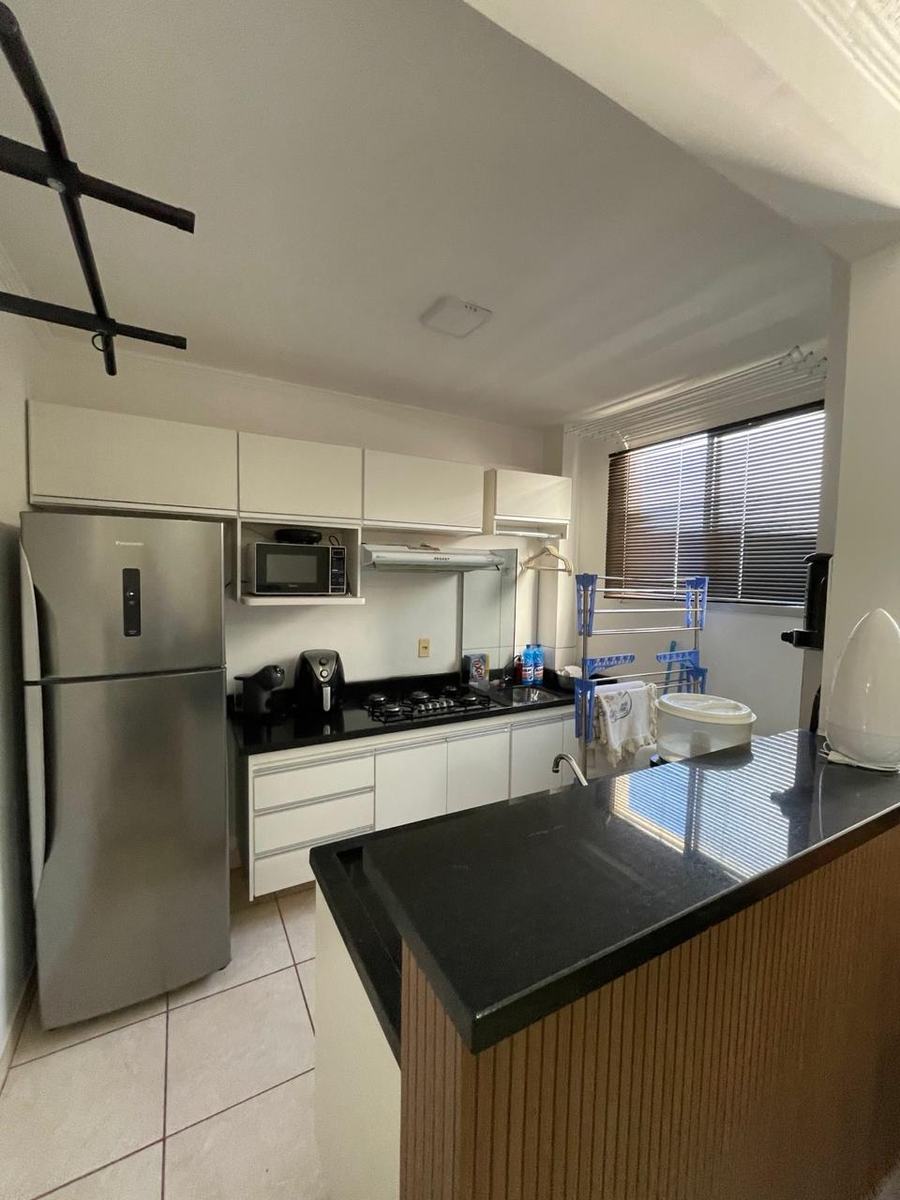 Cozinha planejada com cooktop, coifa e bancada de mármore